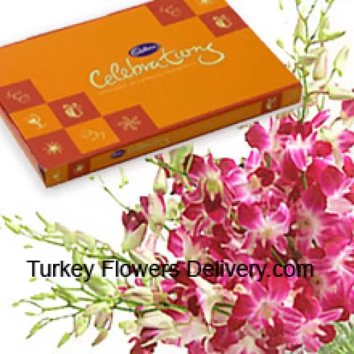 Un hermoso manojo de orquídeas rosadas junto con una hermosa caja de chocolates Cadbury
