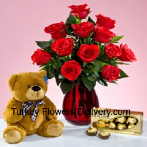 12 Punaiset ruusut muutamilla saniaisilla lasimaljakossa, söpö 12 tuuman pitkä ruskea nallekarhu ja laatikko 16 kpl Ferrero Rocher -suklaata