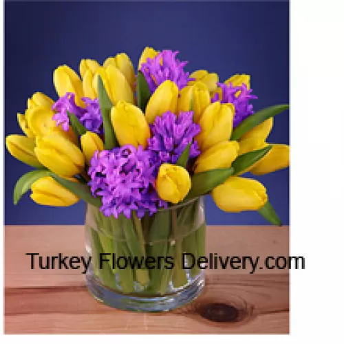 Gelbe Tulpen wunderschön in einer Glasvase arrangiert - Bitte beachten Sie, dass im Falle der Nichtverfügbarkeit bestimmter saisonaler Blumen diese durch andere Blumen von gleichem Wert ersetzt werden.