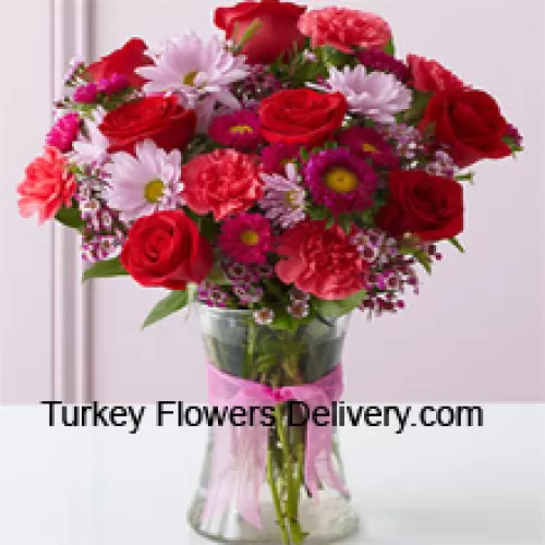 רוזים אדומים, כרנציות אדומות ופרחים מעורבים נערכים בצורה יפה בכלי זכוכית