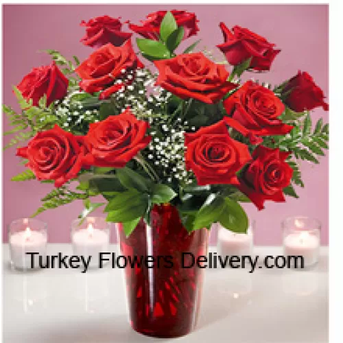 12 красных роз с папоротниками в стеклянной вазе