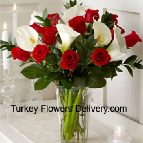 Trandafiri roșii și crini albi cu câteva frunze de ferigă într-un vas de sticlă