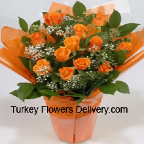 Um belo arranjo de 18 rosas laranja com complementos sazonais