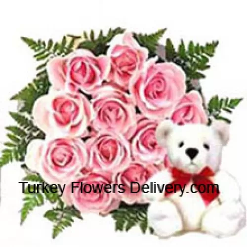 Tros van 12 roze rozen met een schattige teddybeer