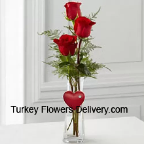 玻璃花瓶中的3朵红玫瑰，上面挂着一个小心形