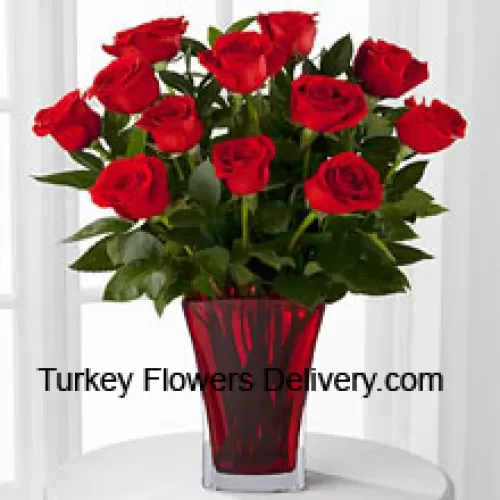 12 rode rozen met wat varens in een vaas