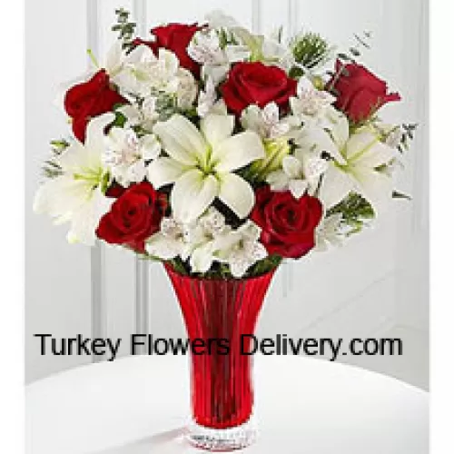 Questo bouquet è una splendida espressione di gioia ed eleganza natalizia. Le rose rosse spiccano su uno sfondo di gigli bianchi asiatici e gigli peruviani amorevolmente disposti in un vaso di vetro rosso per creare un bouquet di celebrazione stagionale. (Si prega di notare che ci riserviamo il diritto di sostituire qualsiasi prodotto con un prodotto adatto di pari valore in caso di non disponibilità di un certo prodotto)